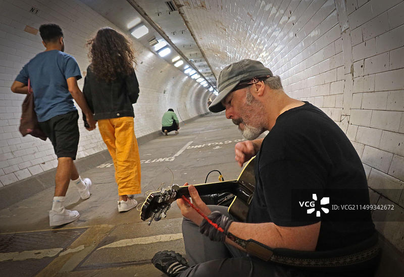 在格林威治泰晤士河人行隧道中娱乐行人的街头艺人，从格林威治到犬岛，伦敦东部，英国图片素材