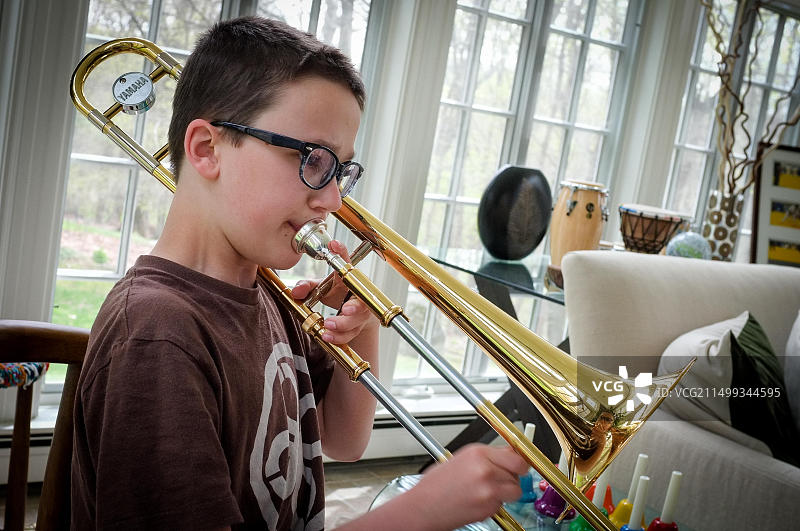 在家练习长号的男孩图片素材