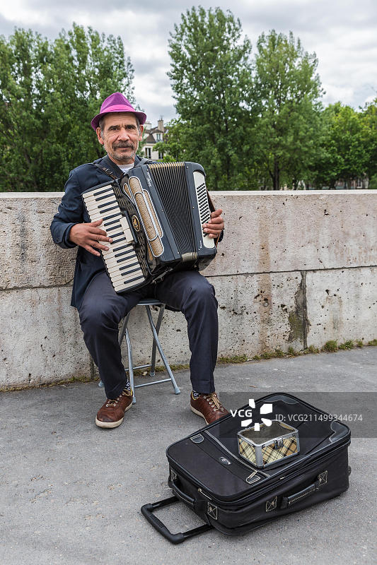 在法国巴黎塞纳河附近演奏手风琴的音乐家图片素材