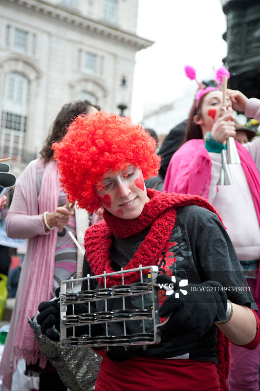 在伦敦皮卡迪利广场情人节活动上戴着红色假发的音乐人，旨在抵制商业化图片素材