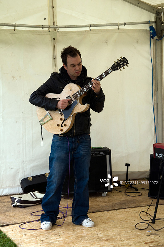 在英格兰东米德兰兹德比郡的美食博览会上弹吉他的男人图片素材