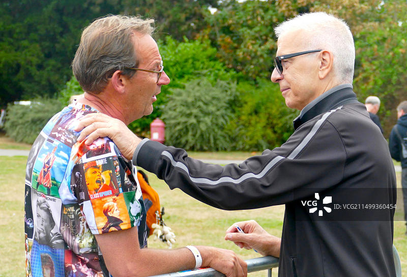 音乐家兼唱片制作人托尼·维斯康蒂在贝肯汉姆的《太空怪谈》活动中与大卫·鲍伊的粉丝交谈。图片素材