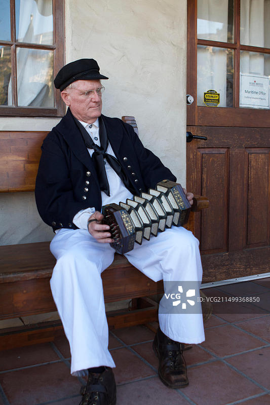 街头表演者打扮成老水手，在码头上用音乐会演奏海歌，东芝高桅帆船节图片素材