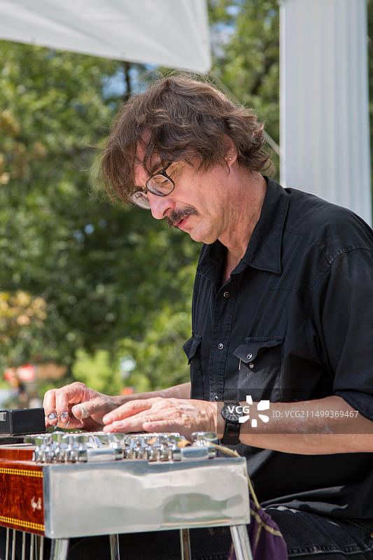 男人弹奏钢棒吉他图片素材