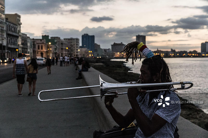 古巴哈瓦那：在马雷贡海滩日落时演奏小号的男人图片素材