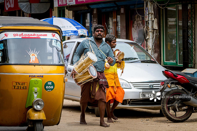 印度男子走在街上，在卡帕利斯瓦拉尔神庙附近敲鼓图片素材
