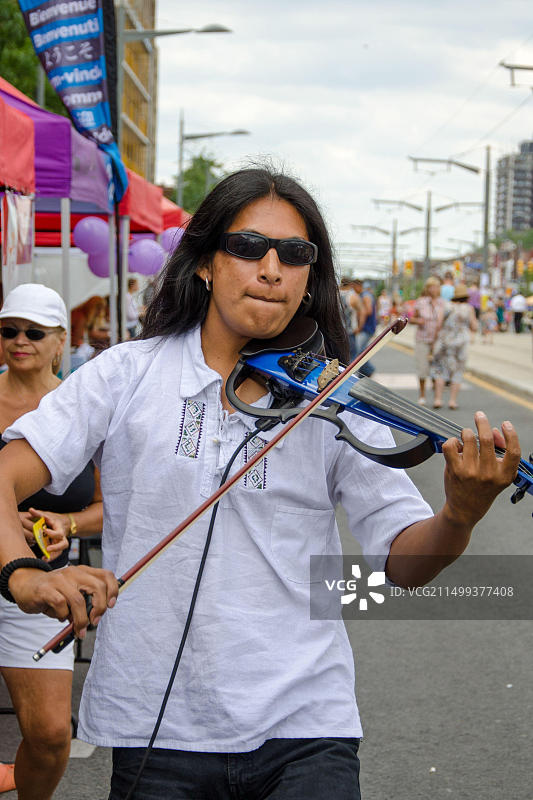 圣克莱尔节上的莎莎舞：街头音乐家为参与者演奏电子小提琴图片素材