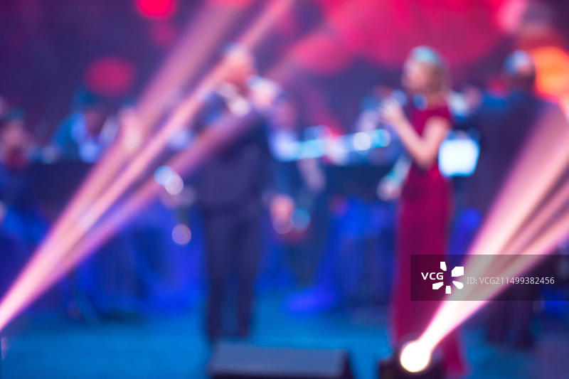 带有歌手和舞台投影光束的模糊音乐会背景图片素材