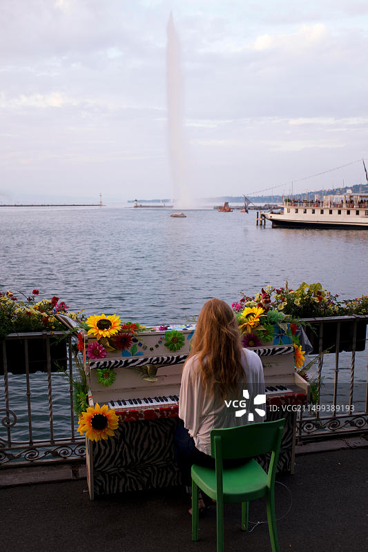 在瑞士日内瓦湖边弹钢琴的女人图片素材
