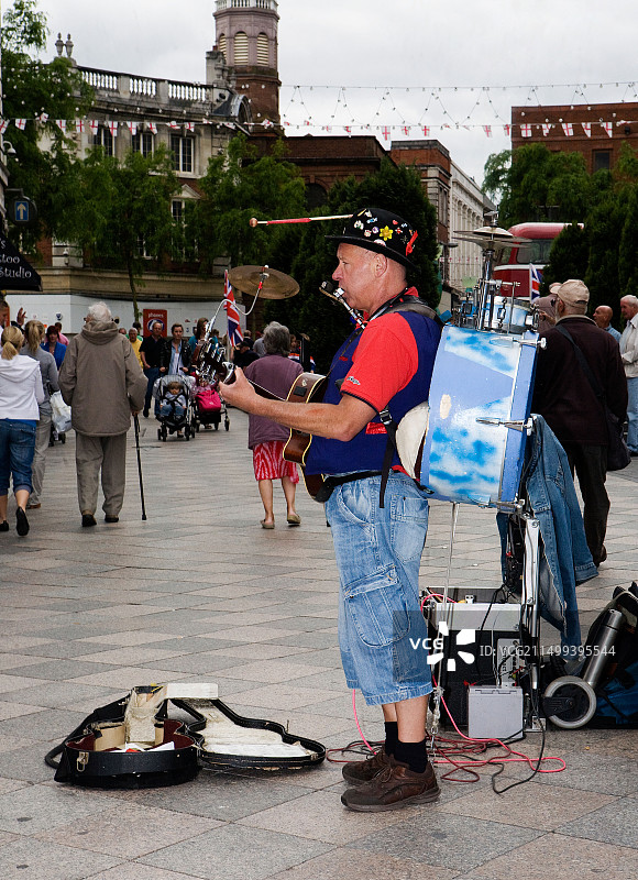 在沃灵顿镇中心举行的老爷车活动中，一个人的乐队在唱歌和演奏图片素材