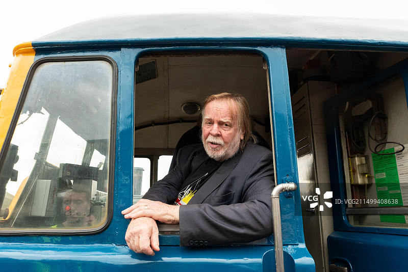 英国埃塞克斯郡克劳奇河畔伯纳姆芒加普斯铁路博物馆。2023年10月1日。摇滚音乐家和铁路爱好者里克·韦克曼在一辆修复的古董31型柴油机车“卡罗琳电台”上揭晓了名牌。这辆编号为31105的柴油机车于1959年制造，英国铁路公司在其干线和其他用途中使用，于2014年退役。这辆机车于2019年抵达芒加普斯，最近被修复成原始的英国铁路蓝色涂装。一个新的卡罗琳电台在当地广播，并参与了命名。韦克曼坐上驾驶室开车。韦克曼在驾驶室准备驾驶图片素材