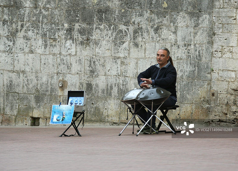 街头音乐家在意大利圣吉米尼亚诺山顶小镇演奏音乐图片素材