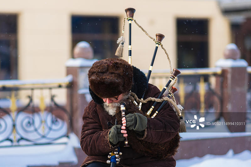 高地人：在莫斯科寒冷的冬日街头演奏风笛的男子图片素材