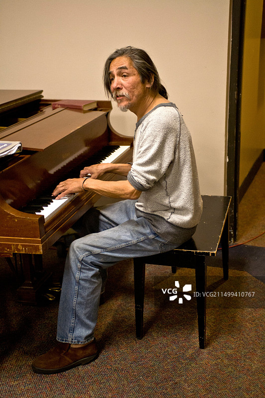 流浪男人在教堂夜间收容所弹钢琴唱歌图片素材