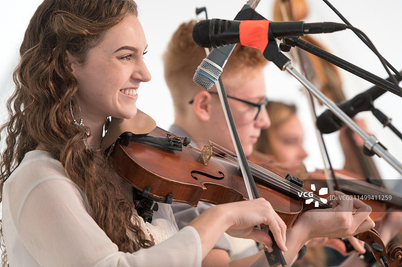 来自Strictly Strings & the Cole Mountain Cloggers乐队的年轻女性在格林斯博罗用小提琴谢幕图片素材
