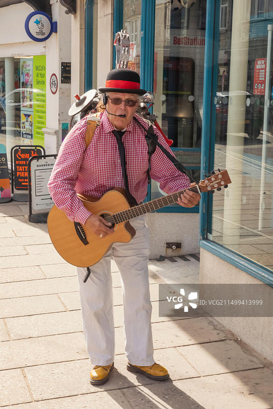 英国多塞特珀贝克岛斯瓦尼奇民俗节，老年单人乐队演奏吉他唱歌图片素材