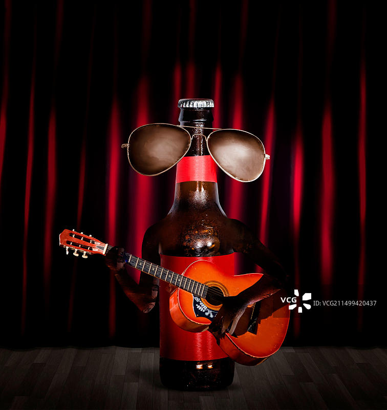 音乐表演者在舞台上弹吉他（未开封啤酒瓶）图片素材