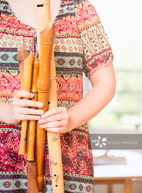 手持各式木制长笛的女子特写图片素材