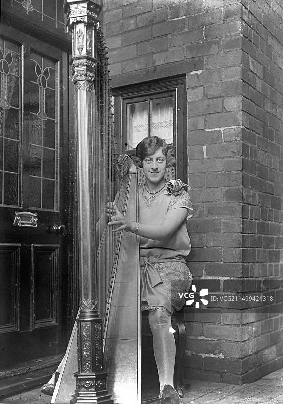 一位英国竖琴师在她家门外与乐器合影，约1910年图片素材