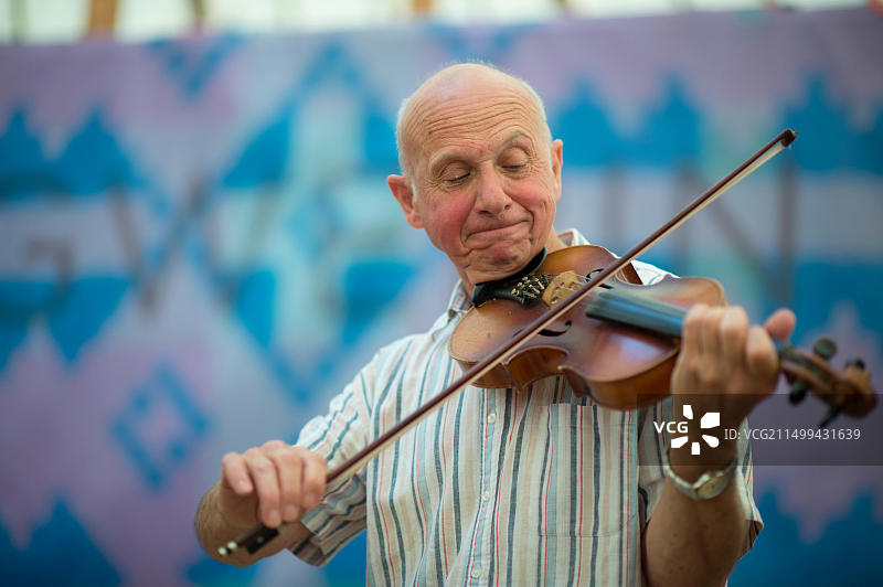 一位年长的成年男子在2014年8月于英国威尔士拉内利国家音乐节上用小提琴演奏传统民间音乐图片素材
