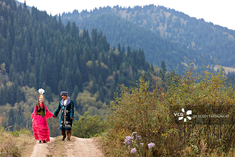 身着民族服装的哈萨克族夫妇在哈萨克斯坦阿拉木图手牵手散步图片素材