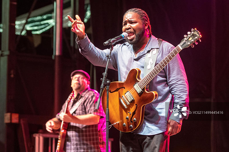 在索尔兹伯里国家民俗节上，布鲁斯表演者马奎斯·诺克斯在舞台上对着麦克风唱歌图片素材