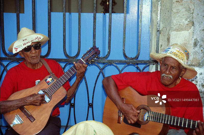 在古巴哈瓦那大教堂广场演奏吉他的古巴老人，加勒比街头音乐图片素材