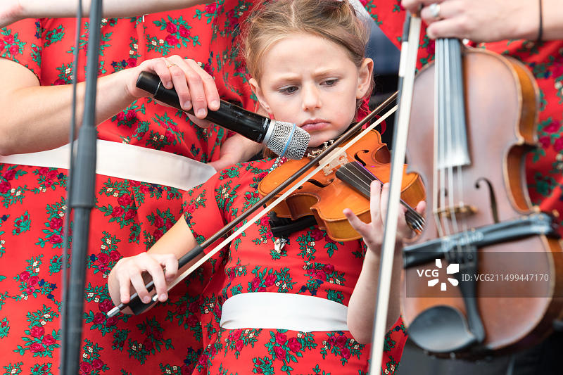 来自Pan Franek、Zosia和Polka Towners的小女孩在北卡罗来纳州格林斯博罗国家民俗生活节上演奏小提琴图片素材