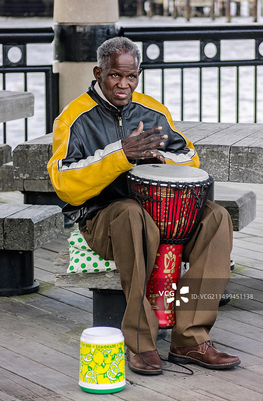 一名非裔美国男子在查尔斯顿海滨公园码头演奏西非金贝鼓图片素材