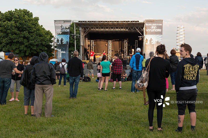 在加拿大安大略省伯灵顿市斯宾塞史密斯公园举办的“音乐之声节”上观看乐队表演的小型人群图片素材