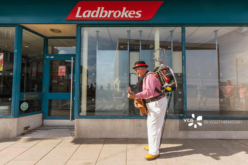 英国多塞特珀贝克岛斯瓦尼奇民俗节，老年单人乐队演奏吉他唱歌图片素材