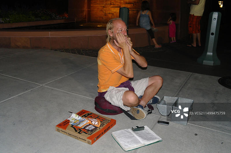 中年白人男子在犹他州盐湖城街头演奏口琴图片素材