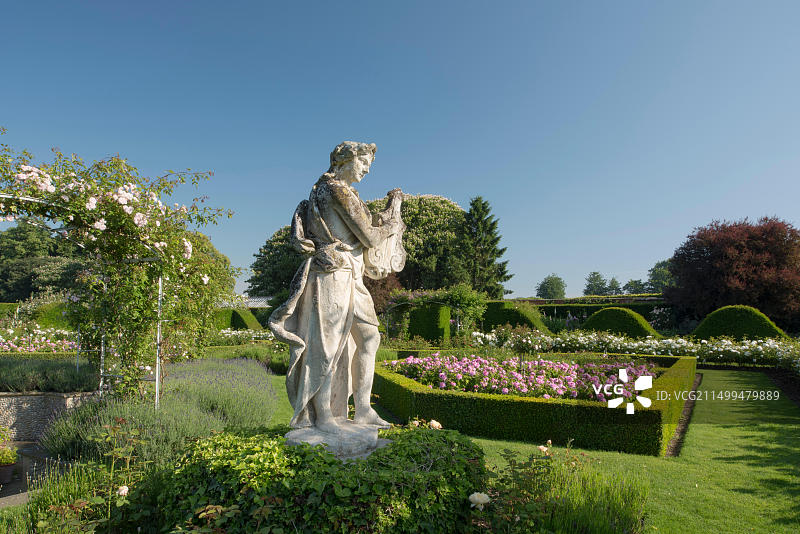 英国诺福克霍顿庄园：玫瑰花坛中弹奏琵琶的石头雕像图片素材