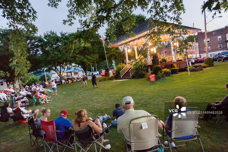 社区居民在纽约州黑兹利特公园的乐队演奏台下欣赏音乐会图片素材