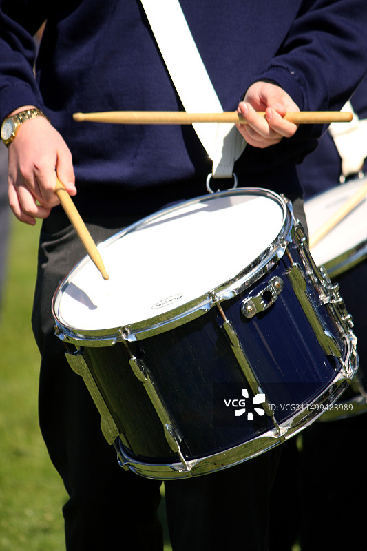 在学校游行队伍中敲鼓的男孩图片素材
