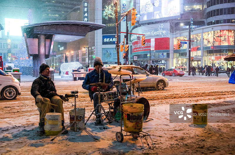 加拿大多伦多：夜晚央街-登打士广场的街头音乐家在暴风雪中演奏图片素材