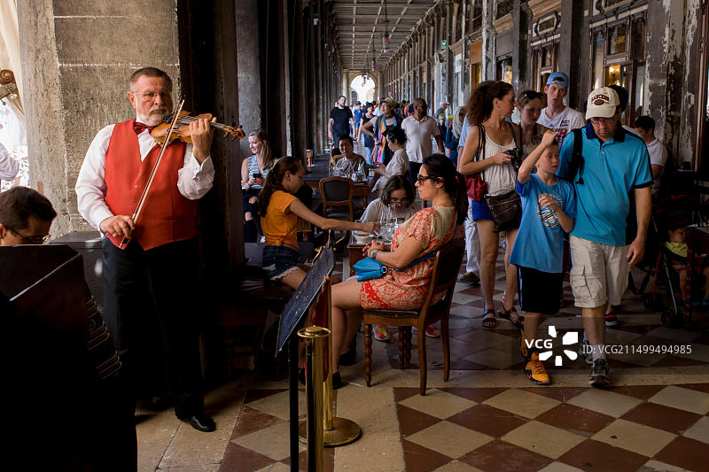 小提琴手在威尼斯圣马可广场新行政官邸大楼内演奏图片素材