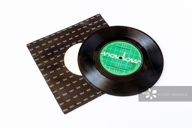 7寸每分钟45转的单曲黑胶唱片：埃尔维斯·科斯特洛的《陌生人之家》，带原装封套，白色背景隔离图片素材