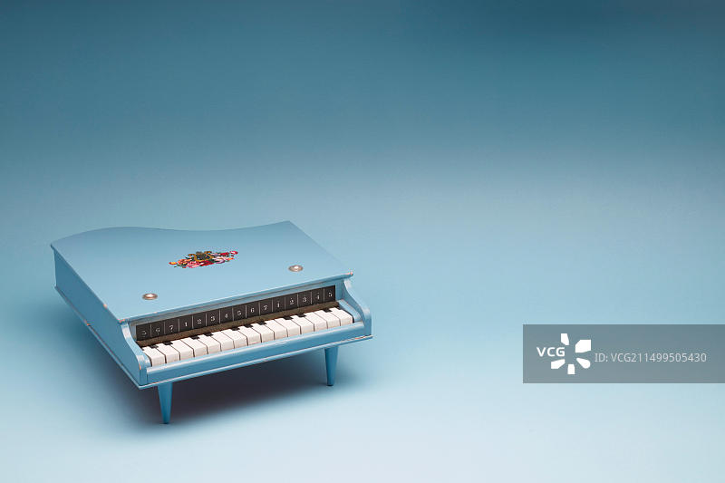 蓝色背景上的玩具三角钢琴图片素材