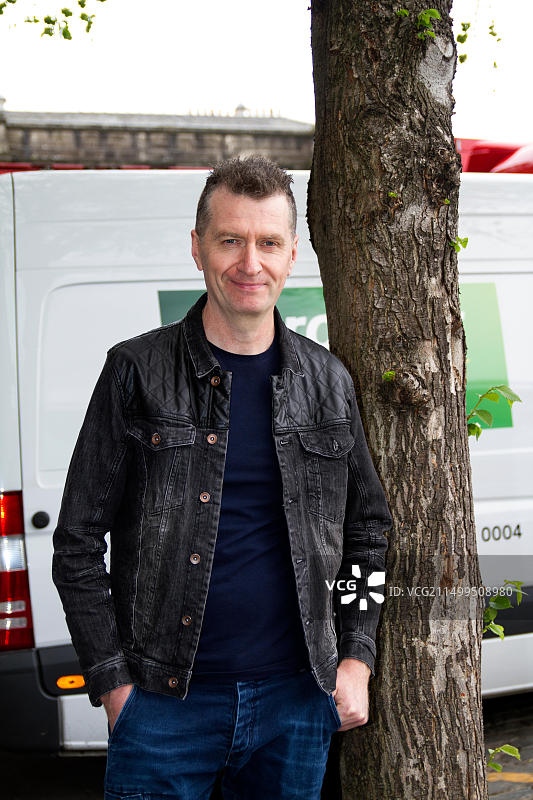 邓迪，泰赛德，苏格兰，英国。1980年代摇滚乐队Simple Minds抵达邓迪，开始英国巡演。贝斯吉他手Ged Grimes在今晚7点30分现场音乐会前抵达凯尔德音乐厅后台入口。图片来源：Dundee Photographics / Alamy Live News图片素材