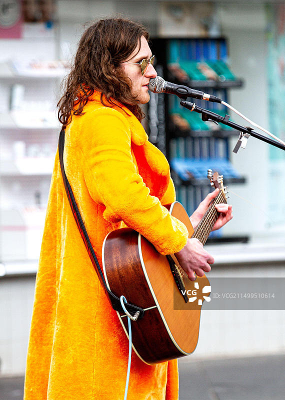 2022年6月1日英国苏格兰泰赛德邓迪:多云天气,有阳光和少量降雨,气温达到14摄氏度。当地华丽摇滚表演者在邓迪市中心进行街头表演。康纳·伯恩是一位著名的吉他手和歌手,他演奏了T-Rex、大卫·鲍伊的1970年代歌曲,甚至是披头士乐队的著名歌曲《别让我失望》。图片素材