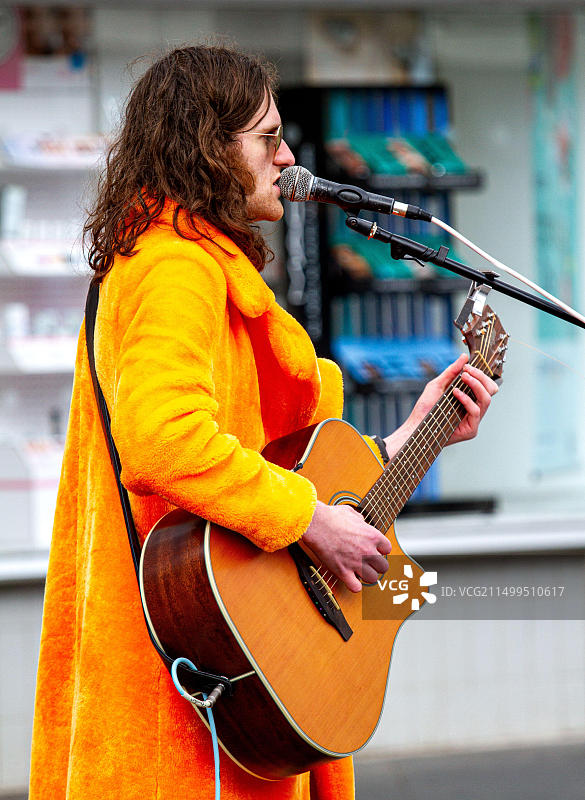 2022年6月1日英国苏格兰泰赛德邓迪：多云天气，有阳光和少量降雨，气温达到14摄氏度。当地华丽摇滚表演者在邓迪市中心进行街头表演。康纳·伯恩是一位著名的吉他手和歌手，他演奏了T-Rex、大卫·鲍伊的1970年代歌曲，甚至是披头士乐队的著名歌曲《别让我失望》。图片素材