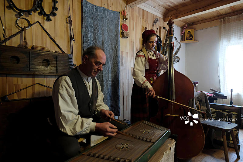 阿列斯·洛斯，白俄罗斯民族志学家，古代民间乐器修复的领军人物，也是一位风笛传统研究者，在白俄罗斯沃洛任地区胡塔尔杜达拉（风笛演奏者农庄）与年轻的白俄罗斯音乐家奥列西亚·西沃希纳一起演奏源自伊朗或美索不达米亚的桑图尔扬琴图片素材