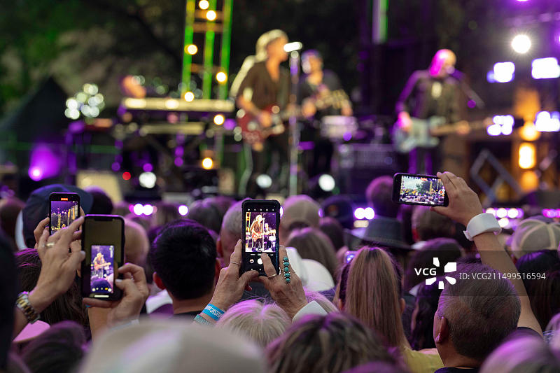 2023年3月29日，美国德克萨斯州奥斯汀：乡村音乐电视（CMT）大奖录制期间，四次格莱美奖得主乡村歌手凯斯·厄本在户外舞台上表演，观众用手机录制视频。图片素材