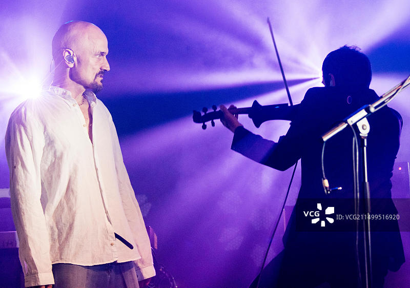 James乐队的Tim Booth在2018年纬度音乐节上现场表演，看着乐队成员Saul Davies演奏小提琴，英格兰萨福克郡亨厄姆公园，2018年7月14日图片素材