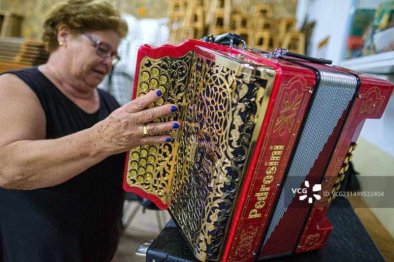 女人拿着一个红色的佩德罗西尼按钮手风琴图片素材