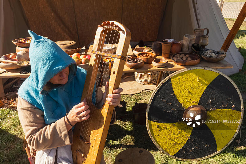 英国东萨塞克斯郡黑斯廷斯年度战役重演节：演奏传统中世纪竖琴的女性图片素材
