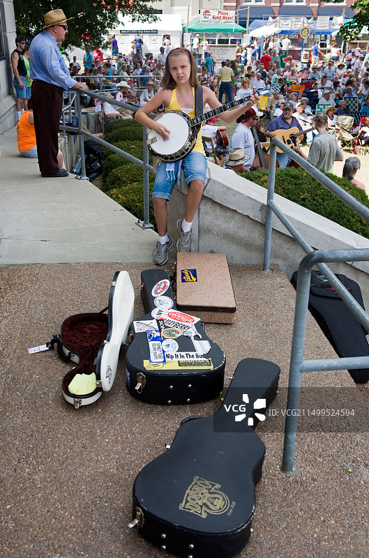 年轻的班卓琴演奏者在乡村音乐节上练习图片素材