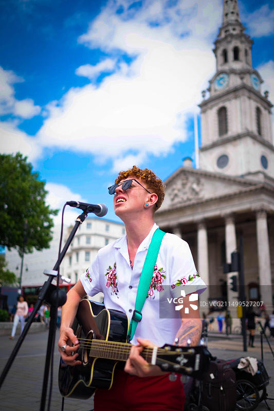 2018年6月19日，英国伦敦特拉法加广场，爱尔兰音乐家鲁本在晴朗的午后为游客演奏音乐图片素材
