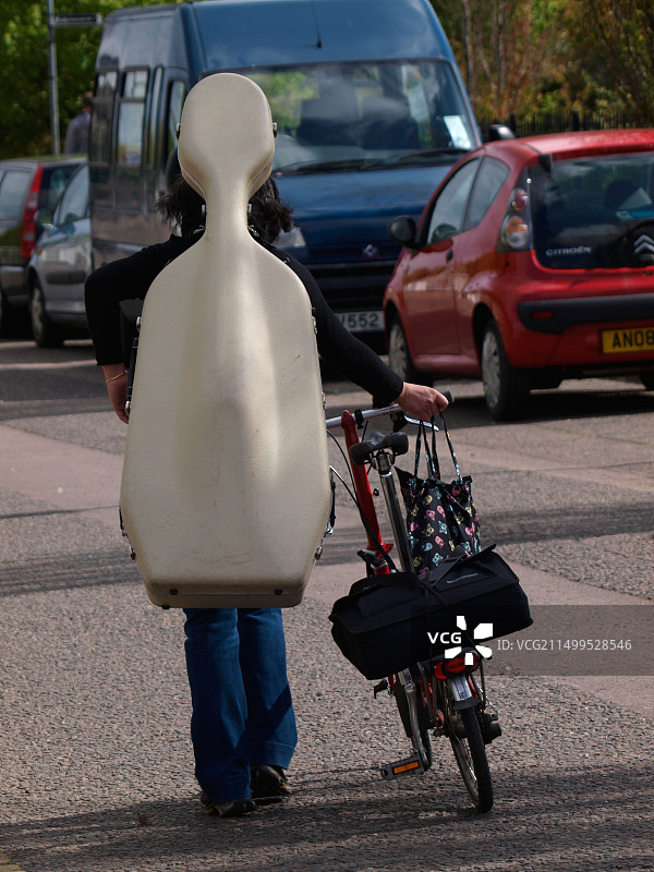 在英国剑桥，背着大提琴的女人图片素材